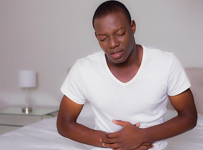 stomach aches man holding mid section