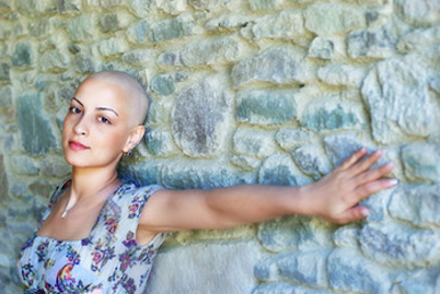 feeding cancer patients bald woman with outreached arm on a wall
